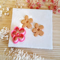 Emporte-pièce fleur Bloom pour bijoux en argile polymère avec découpes sur carreau de céramique.